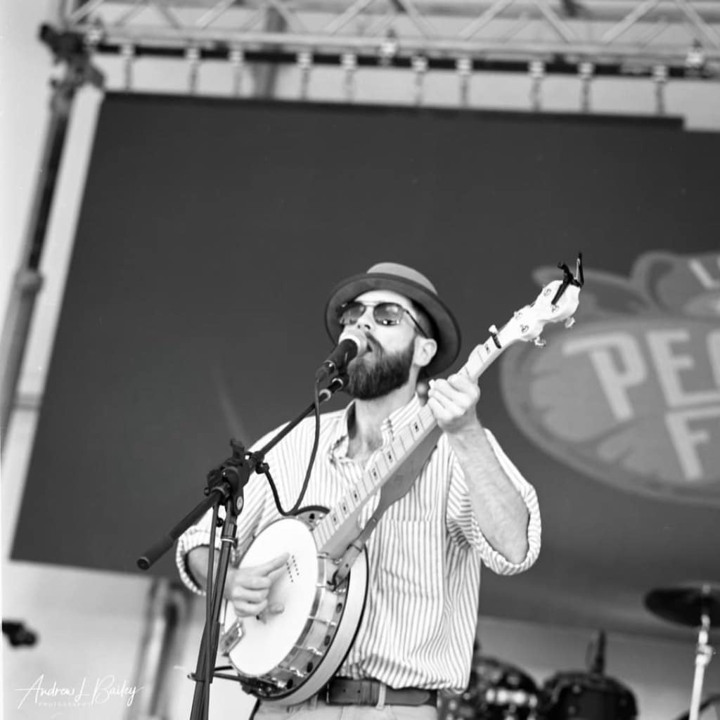 Ira Barger performing on stage, singing and playing the banjo